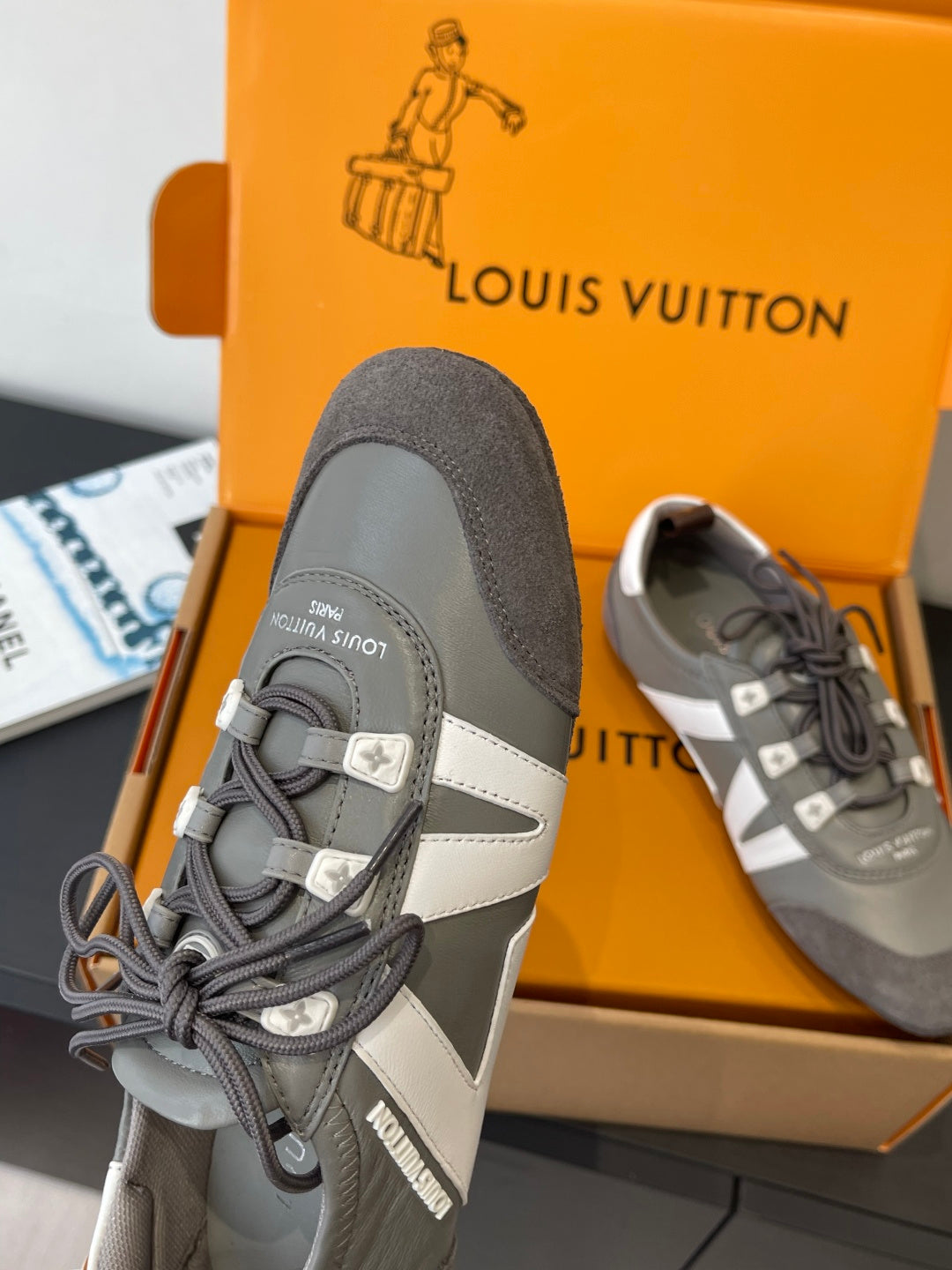 Gray Louis Vuitton lace-up sneaker with white side panel and contrast trim, angle view