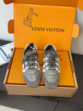 Gray and white lace-up Louis Vuitton sneakers, front view with signature side stripe