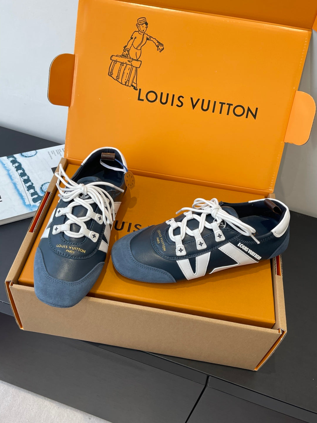 Louis Vuitton unisex sneakers three-quarter view, dark blue suede with white laces and V detail