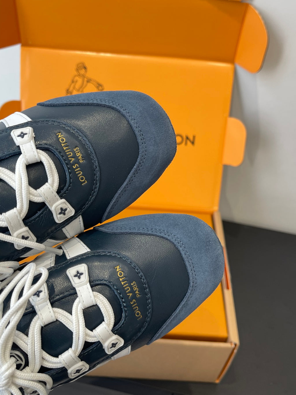 Louis Vuitton unisex sneakers heel close-up, navy suede with white lace eyelets