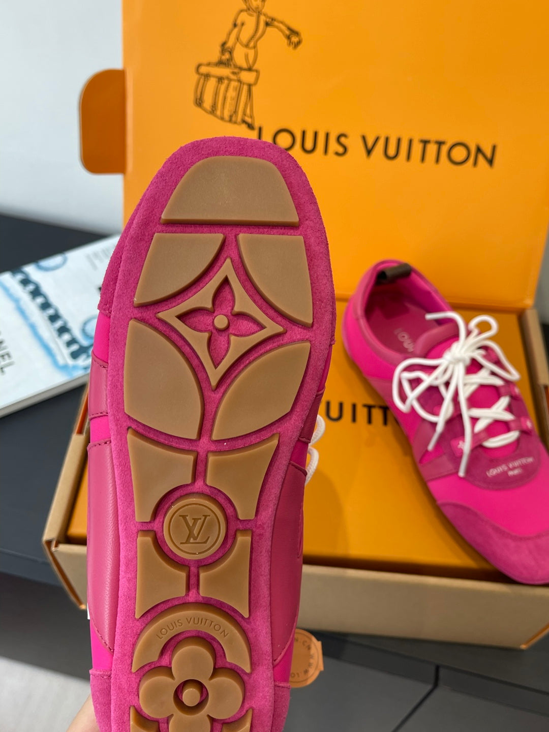 Unisex pink sneakers outsole with decorative monogram pattern, white laces visible