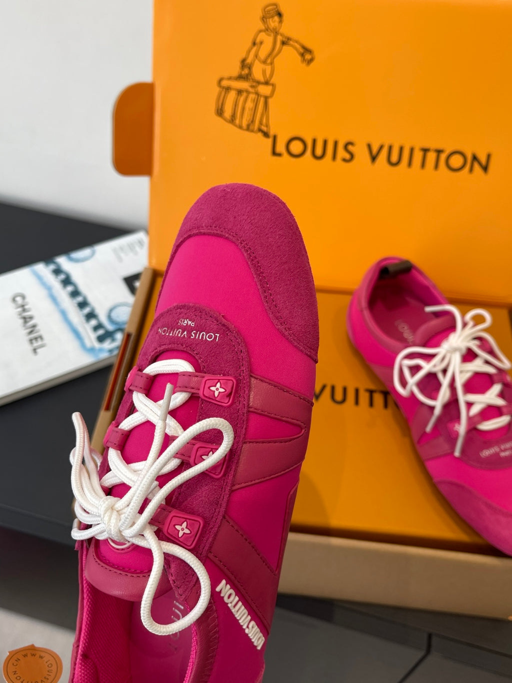 Unisex bright pink sneakers with white lace-up front and padded collar