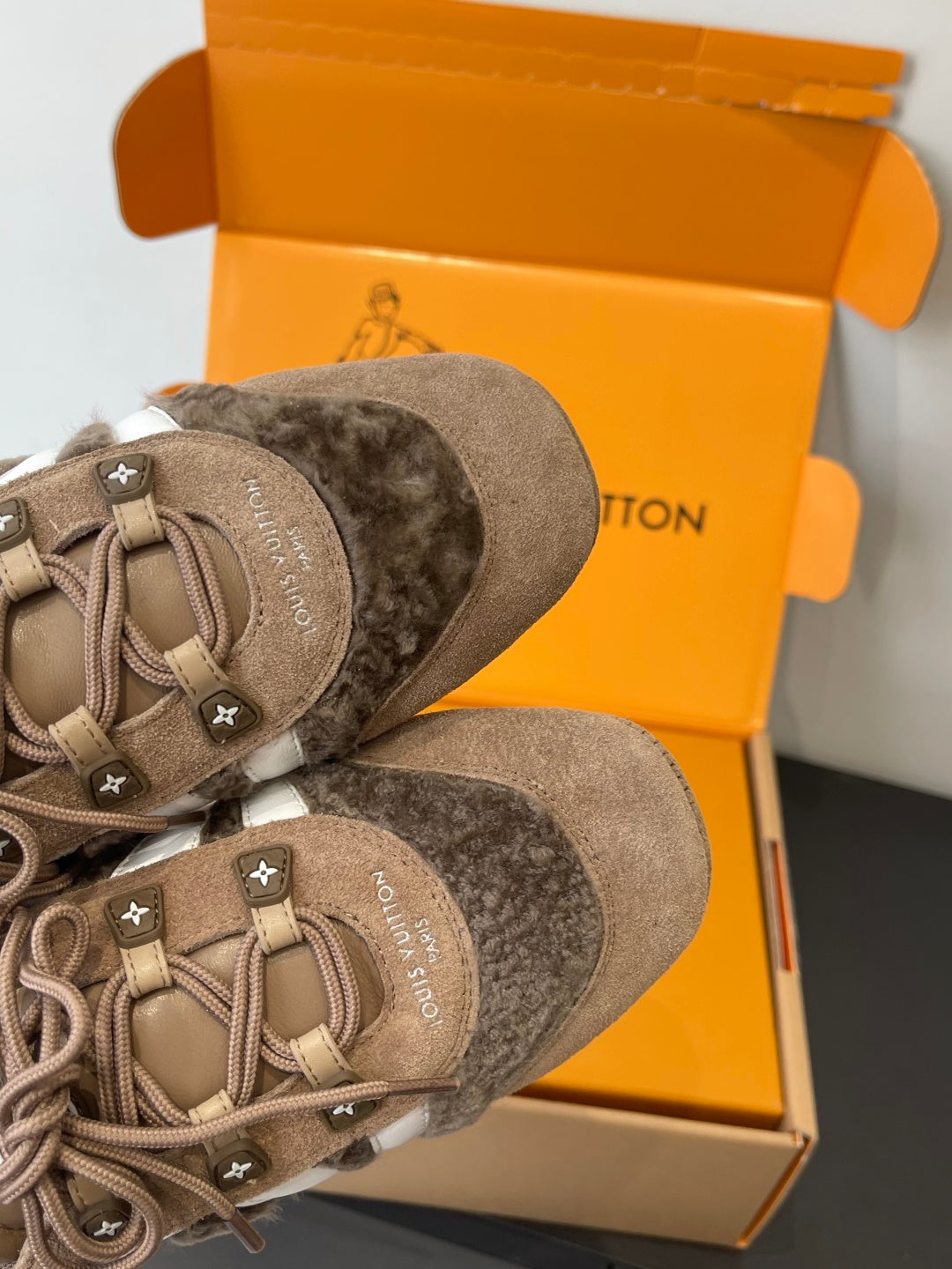 Close-up of gray suede lace-up sneaker with star patch eyelets