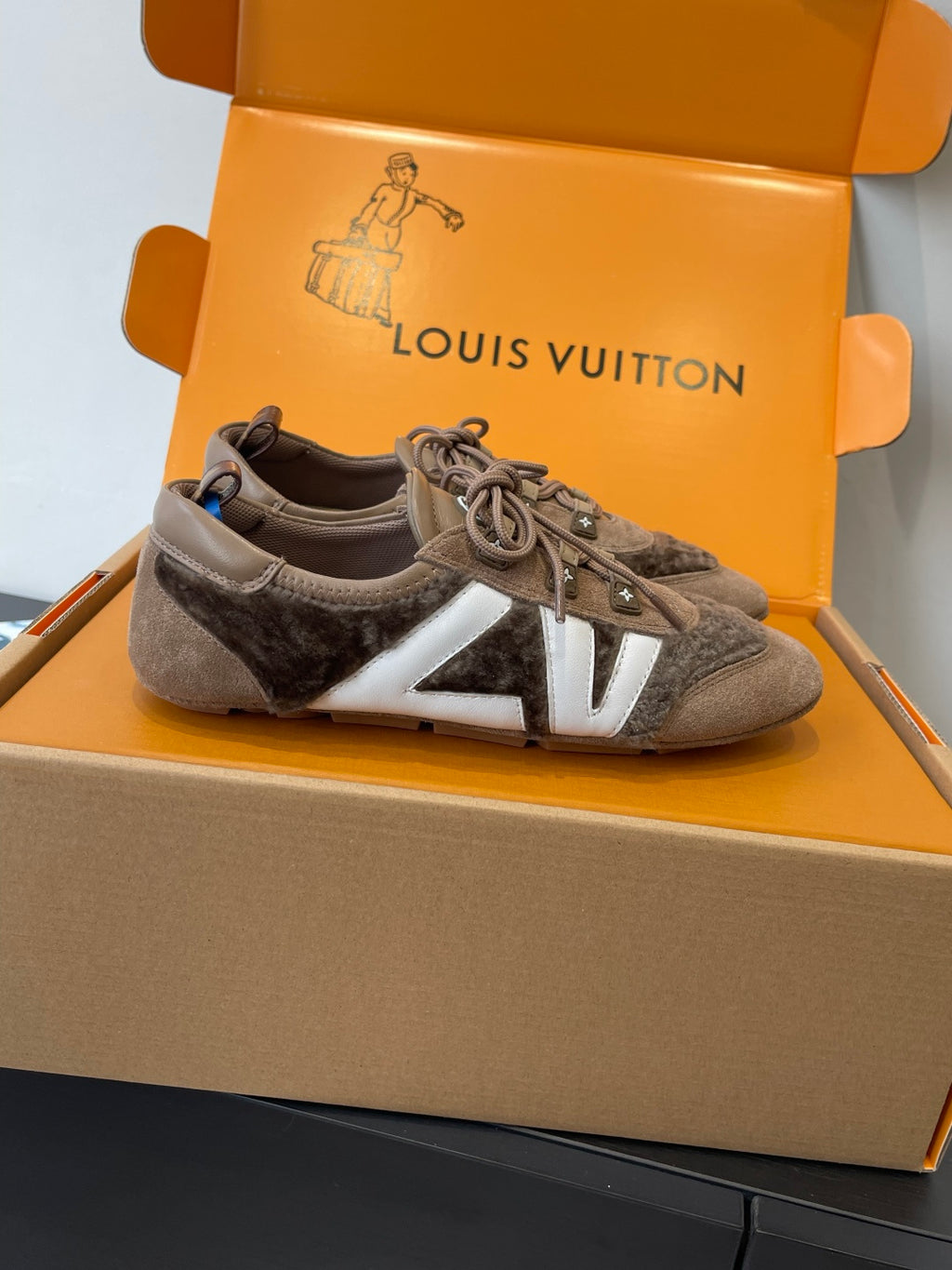 Gray suede lace-up sneakers with white V-style side panel and laces