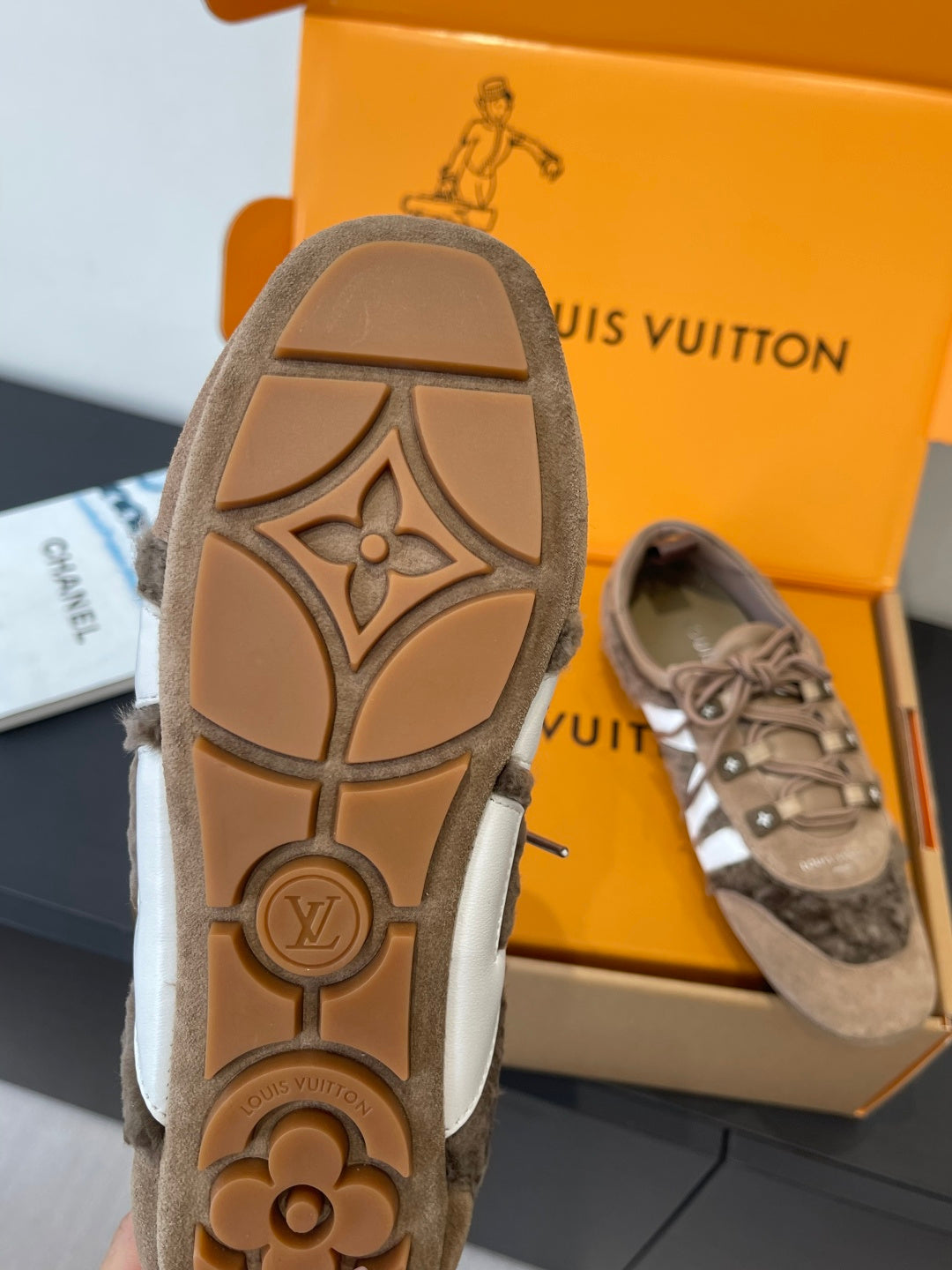 Suede sneaker outsole with brown logo medallion and diamond pattern