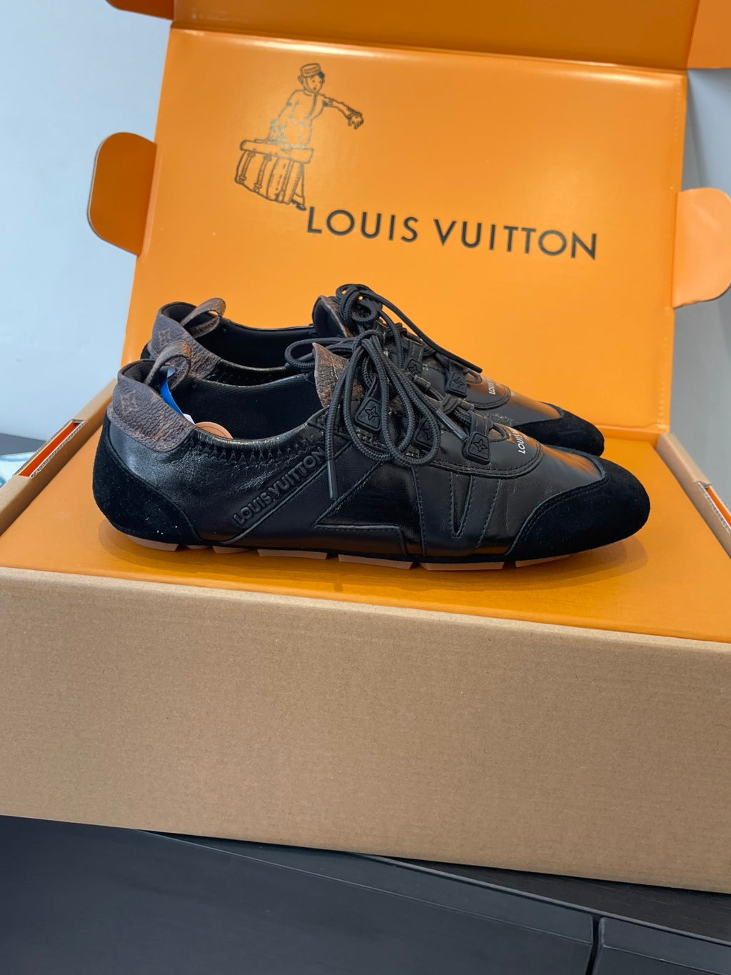 Black leather lace-up sneakers with textured panels and bow laces