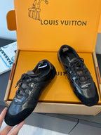 Black lace-up sneakers with metallic leather toe caps and logo patch
