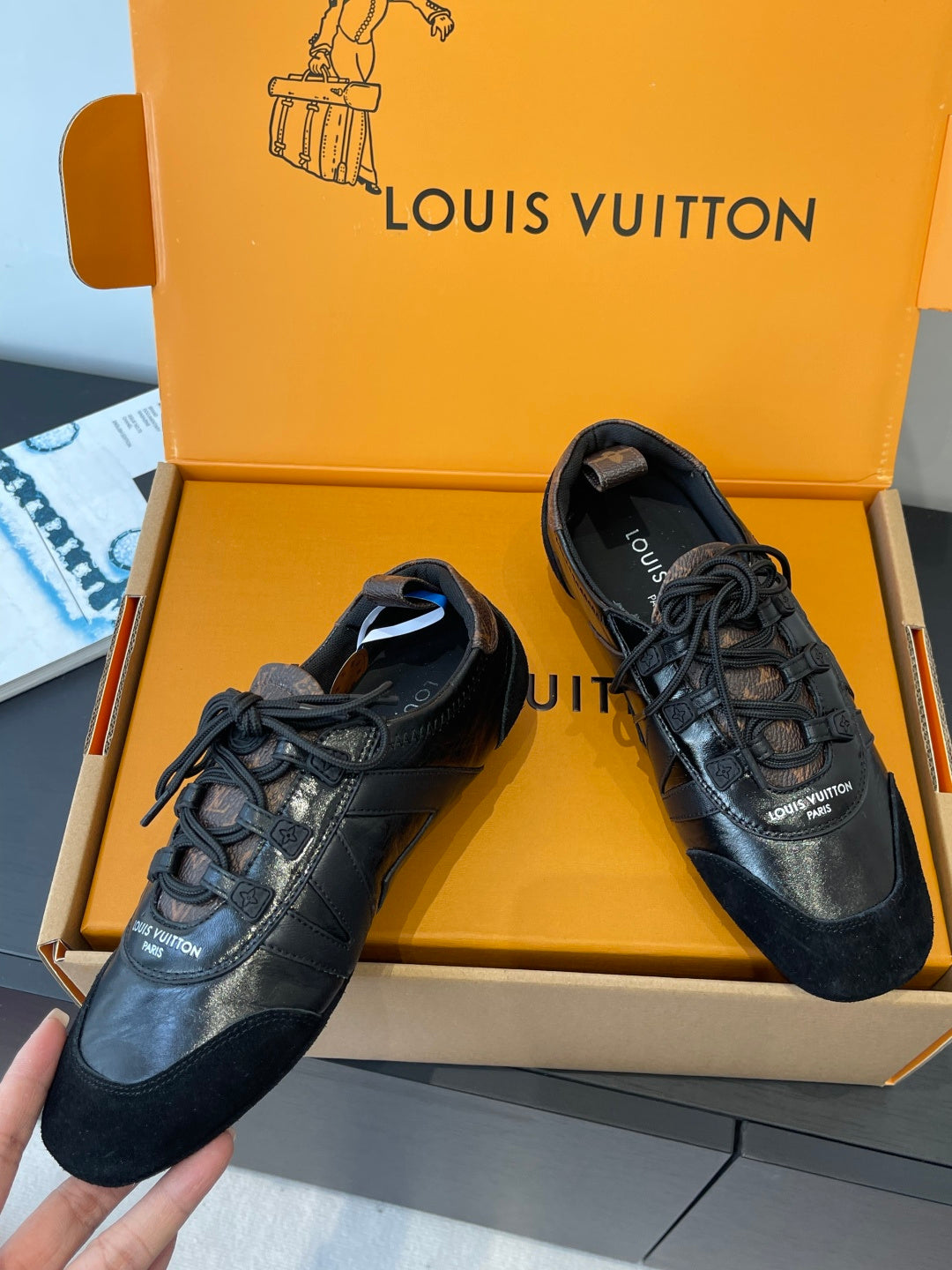 Black lace-up sneakers with metallic leather toe caps and logo patch