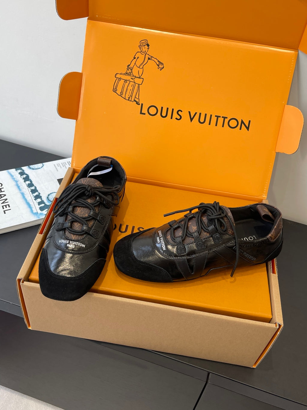 Black leather lace-up sneakers with embossed logo detailing and laces