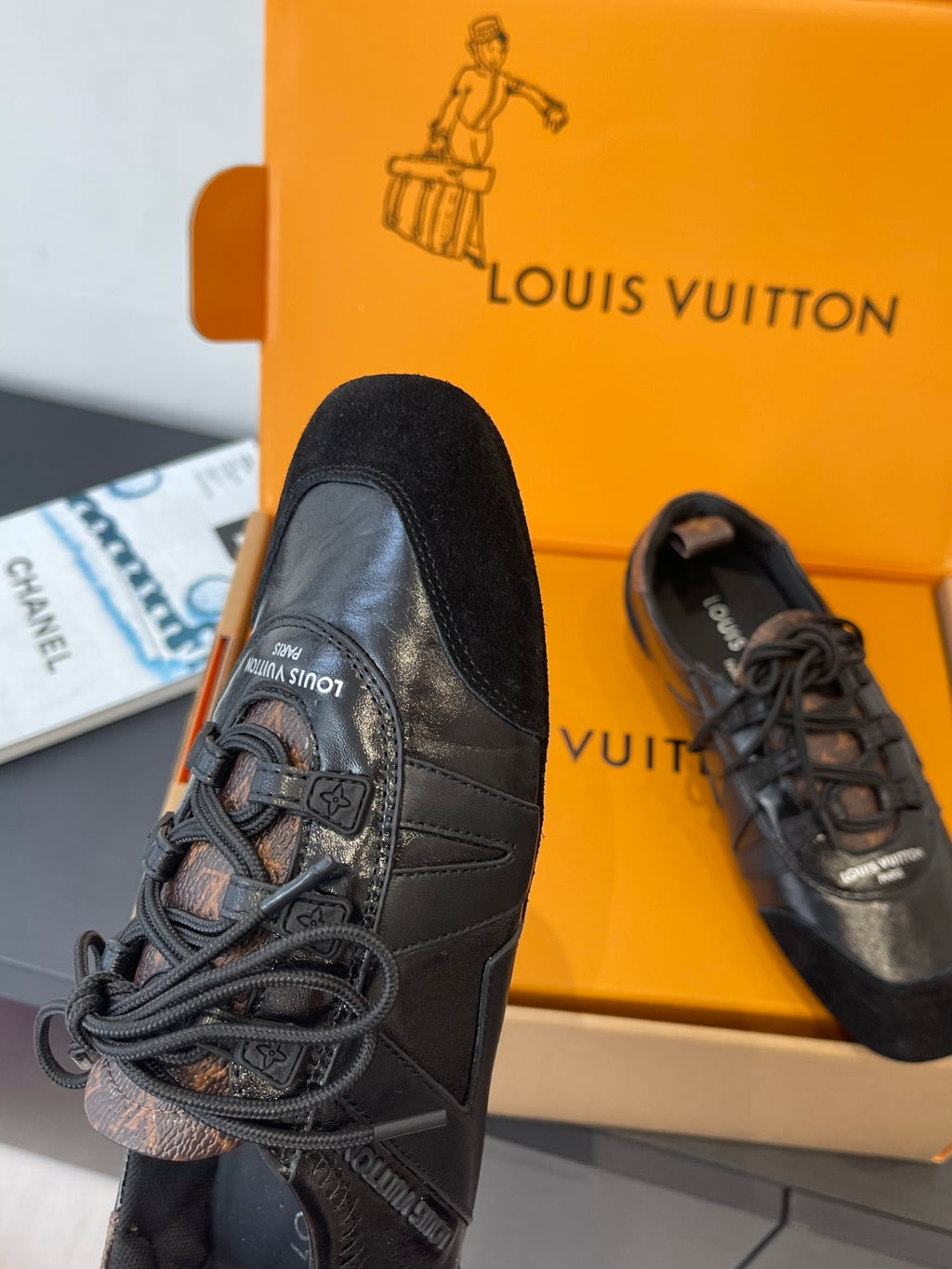 Black lace-up sneakers with stitched leather panels and textured toe