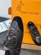 Black lace-up sneakers with stitched leather panels and textured toe