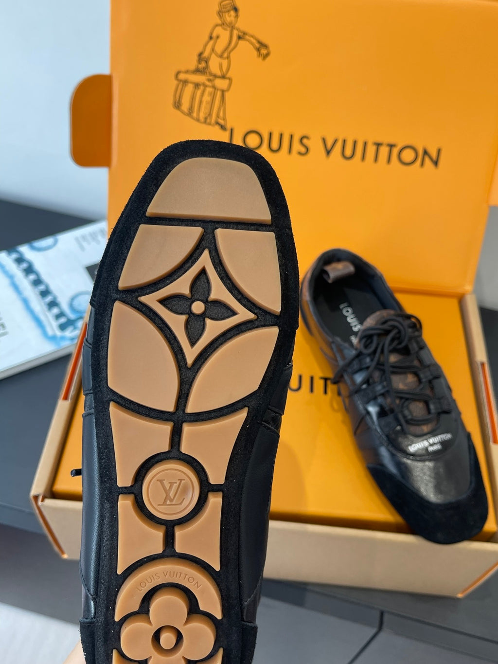 Black sneaker outsole view with LV monogram and flower detail