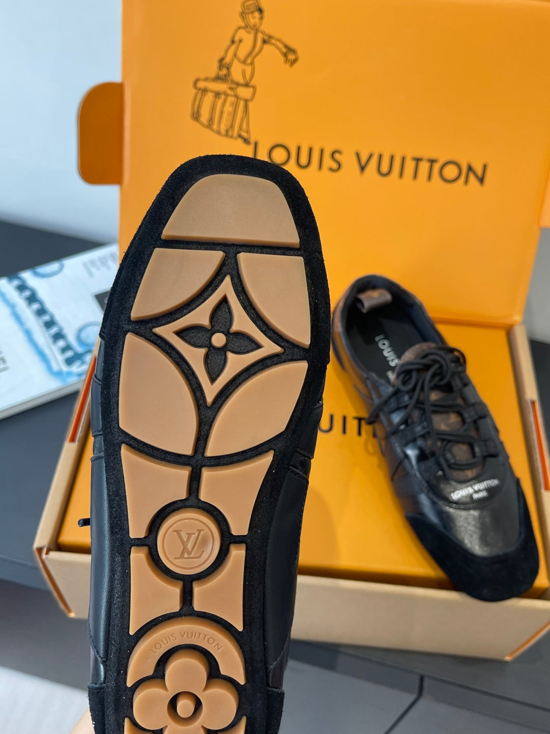Black sneaker outsole view with LV monogram and flower detail