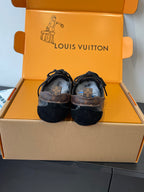 Pair of black lace-up sneakers with Louis Vuitton printed on back tabs