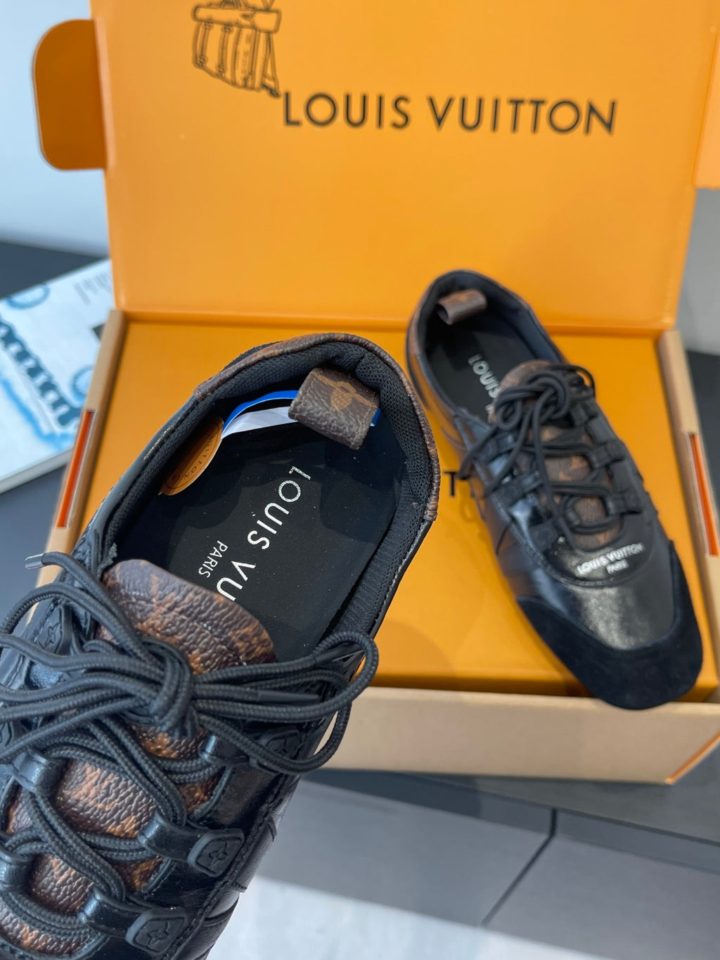 Black lace-up sneakers with Louis Vuitton logo on tongue and laces