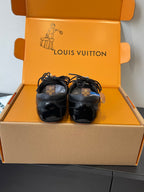 Louis Vuitton unisex black sneakers resting in open box, front view