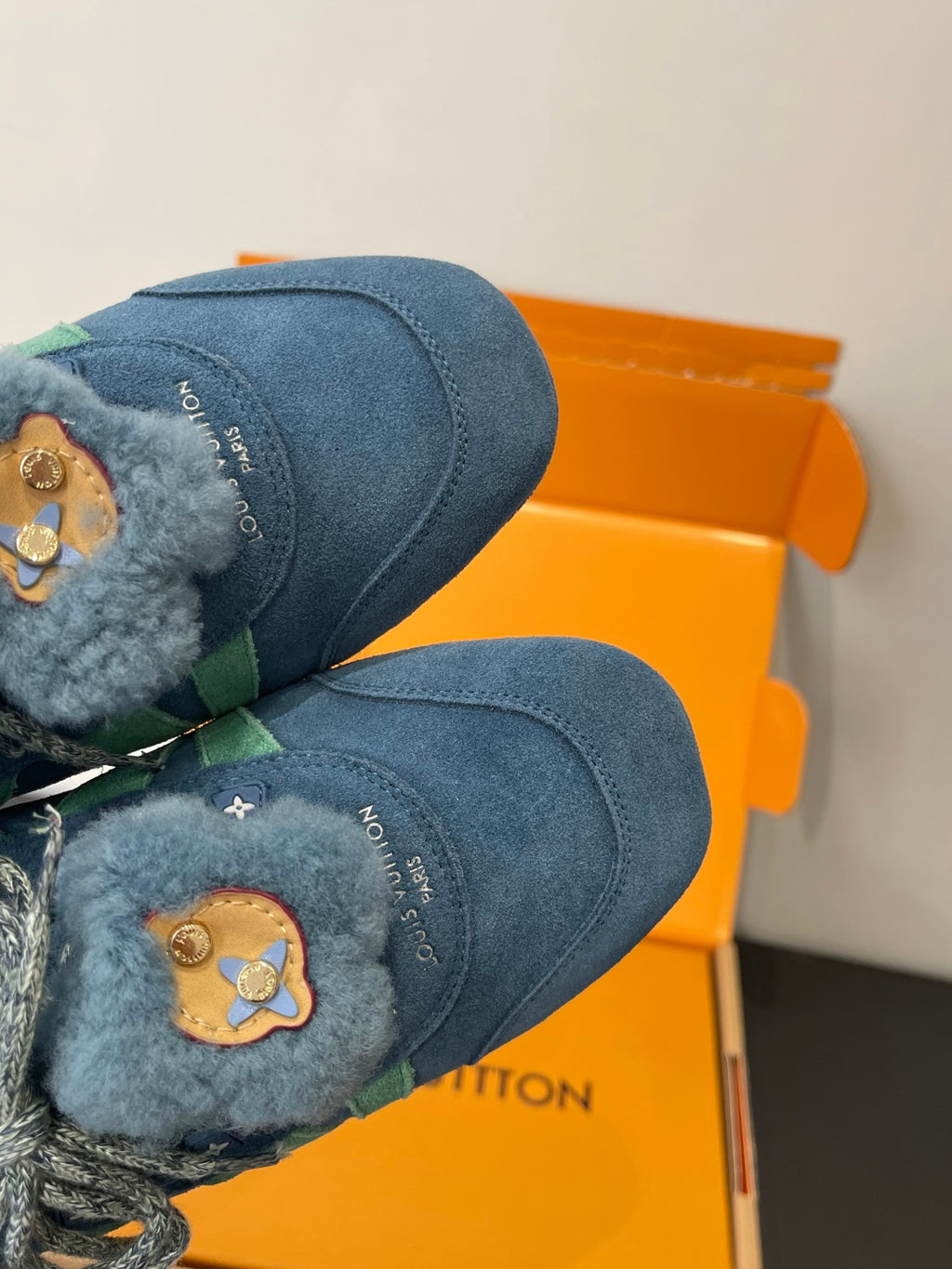 Unisex blue suede sneakers with bear-face patches and fuzzy cuffs, toe close-up
