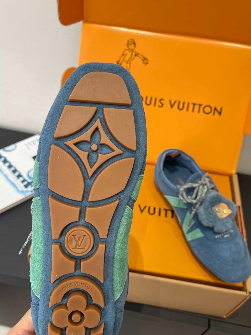 Unisex blue suede sneaker with LV-style logo on outsole, sole view