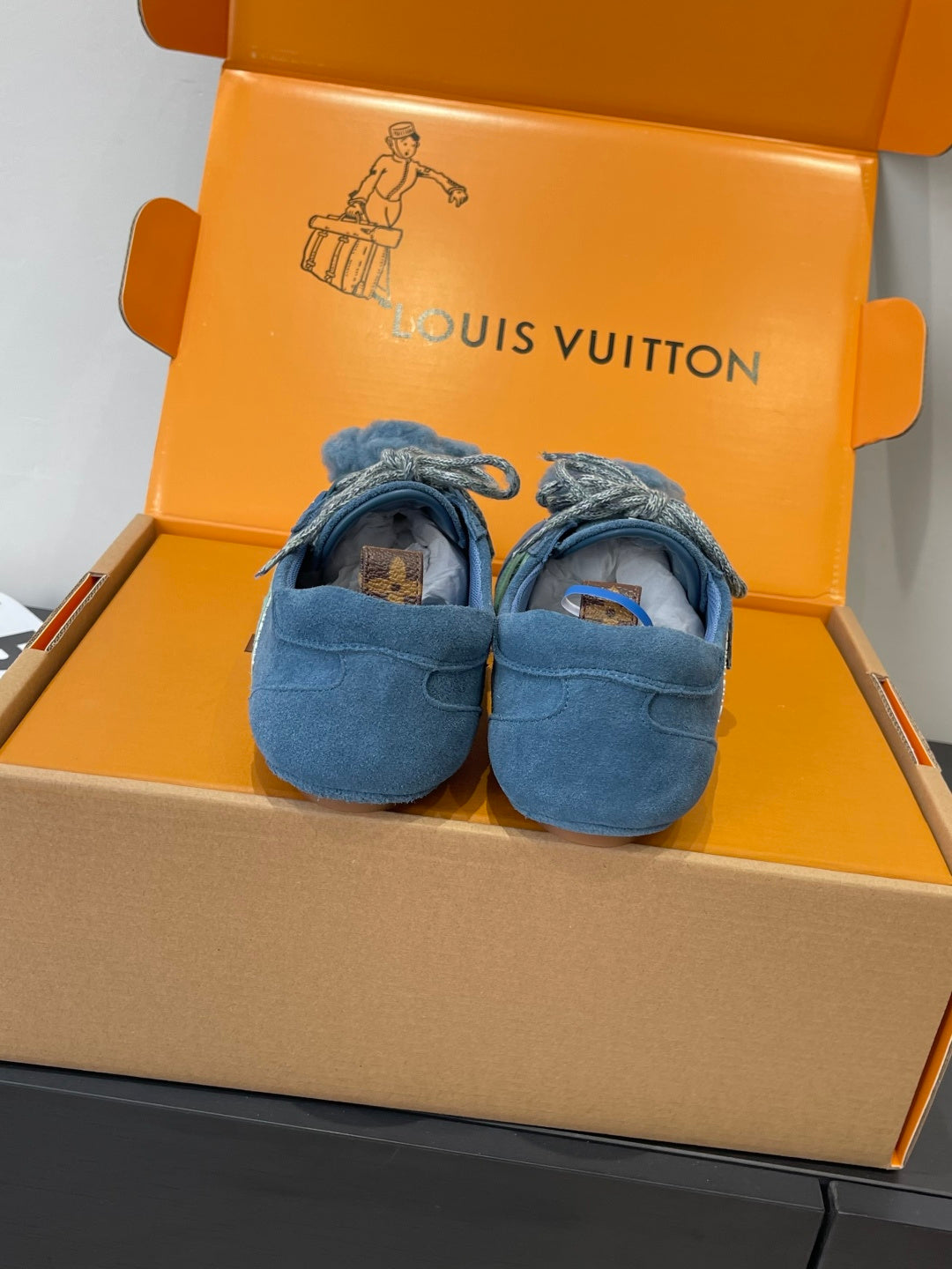 Unisex blue suede sneakers with lace-up bows and bear-face patches, pair view
