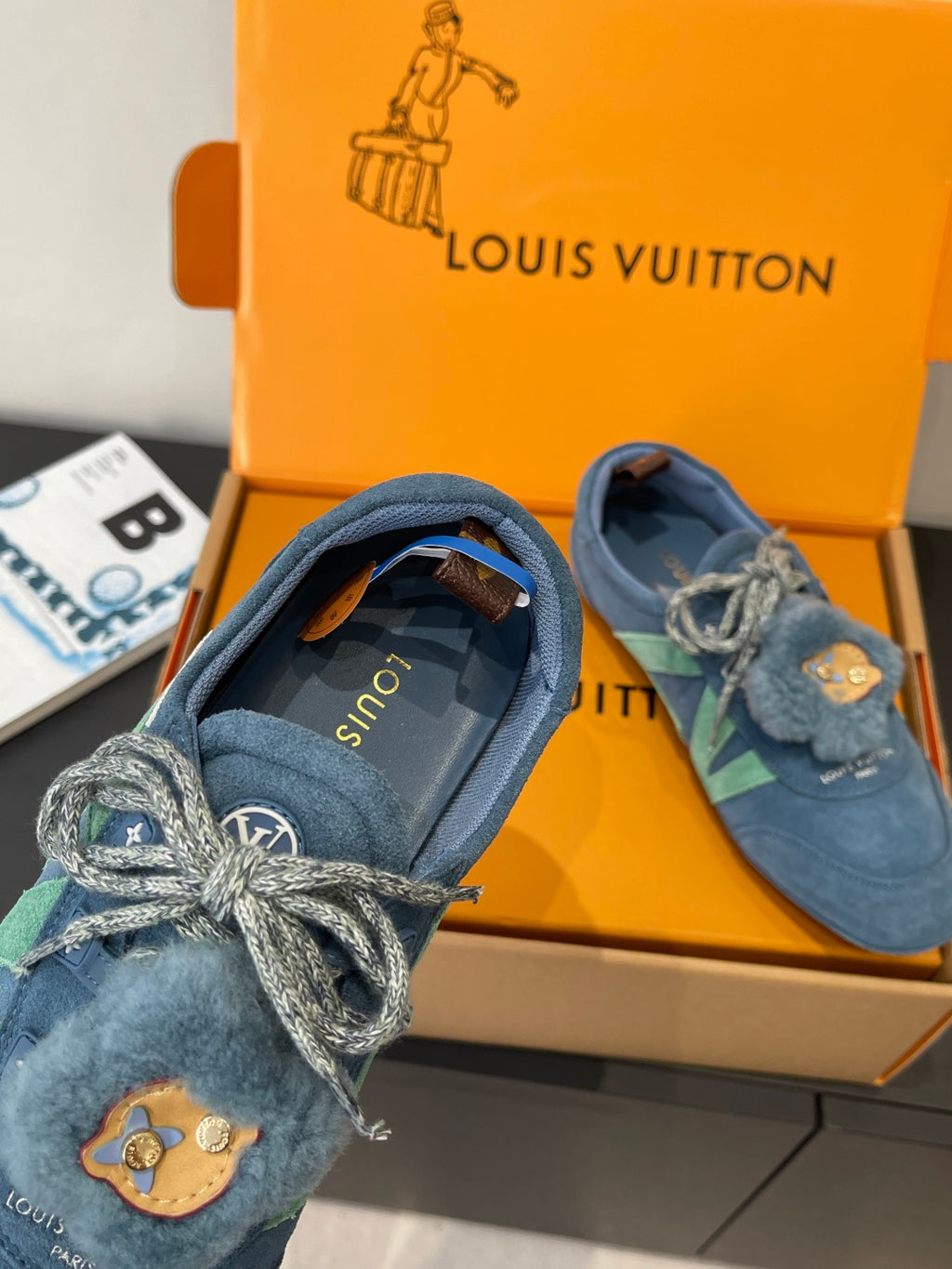 Unisex blue suede sneaker with fuzzy collar, lace-up bow, and bear-face patch