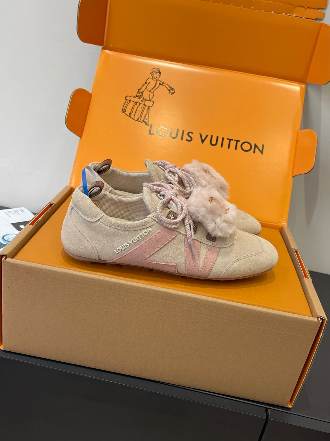 Light beige suede sneaker with pink lace, fur cuff detail, shown in shoe box