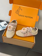 Pair of light beige suede sneakers with pink laces and fur trim, side view in box