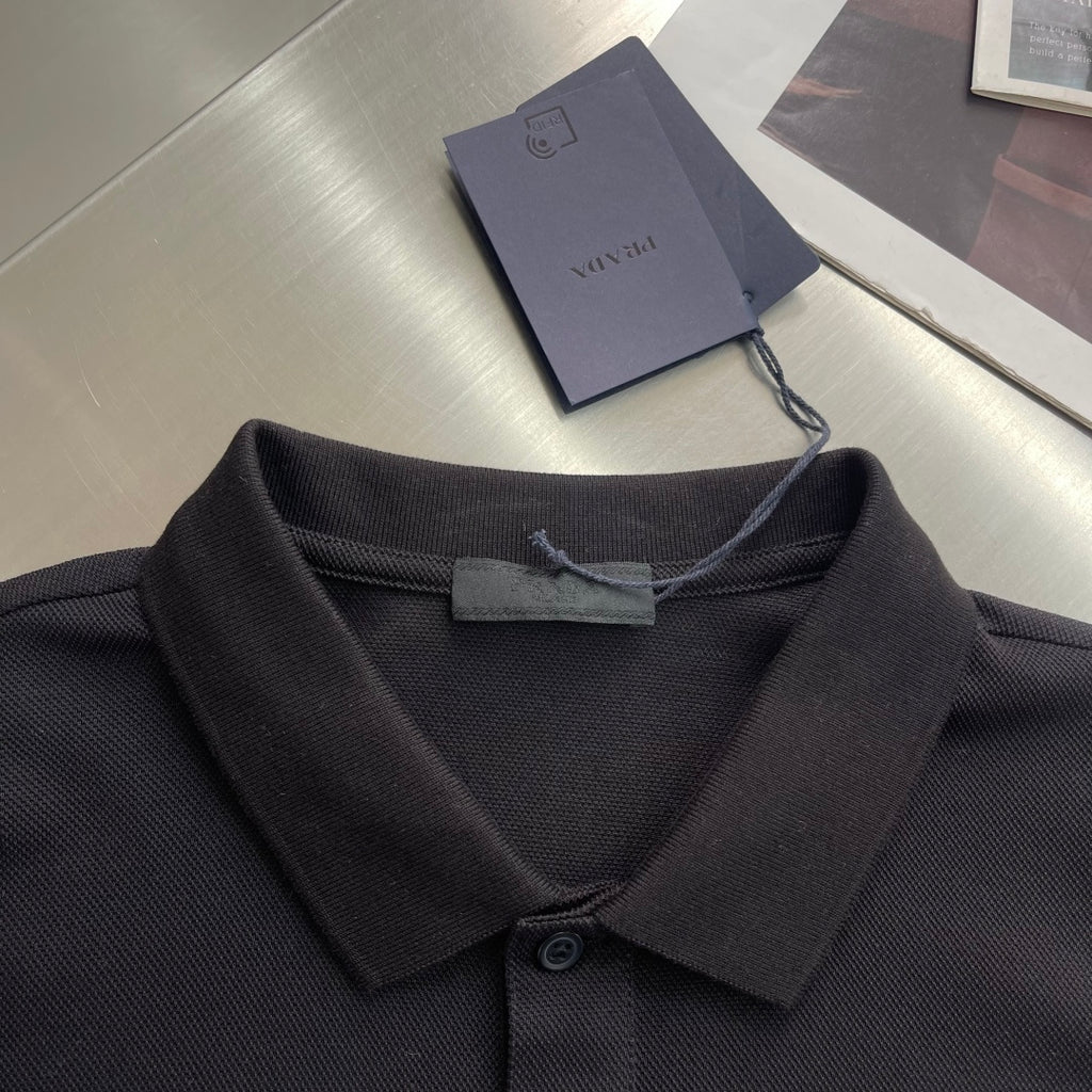 Prada polo shirt neckline close-up, dark fabric with folded collar and button