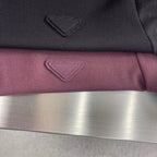 Prada polo shirt logo embroidery on burgundy fabric, close-up with fold