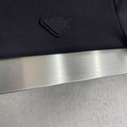 Prada polo shirt chest pocket detail, dark textured fabric with stitched emblem