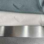 Prada polo shirt close-up of small chest emblem on muted teal knit