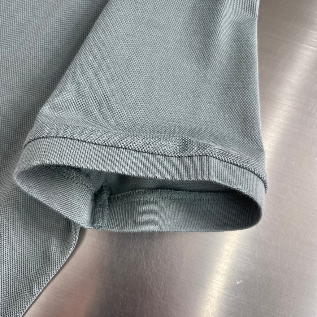 Prada polo shirt sleeve hem with ribbed cuff on muted teal fabric
