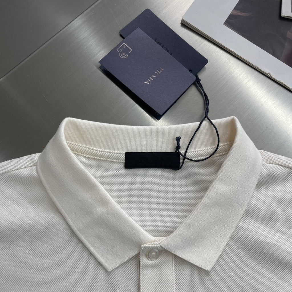 Prada polo shirt collar detail in off-white, with neck button and hanging tag.