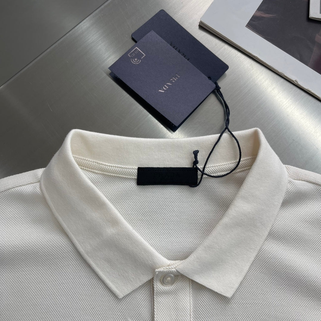 Prada polo shirt collar detail in off-white, with neck button and hanging tag.