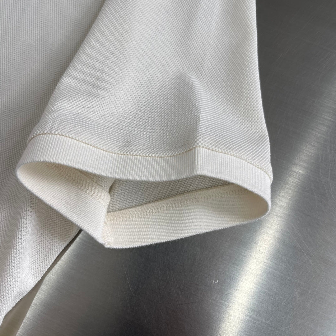 Prada polo shirt hem and sleeve cuff in off-white, folded edge detail.