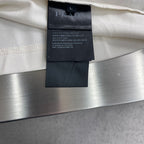 Prada polo shirt interior care tag on off-white fabric.