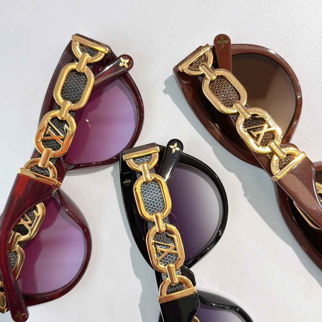 Louis Vuitton sunglasses with gold chain strap detail and purple-brown tinted lenses
