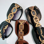 Louis Vuitton sunglasses close-up with gold chain accents and dark lenses