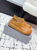 Brown leather slip-on loafers with rounded toe and smooth upper.