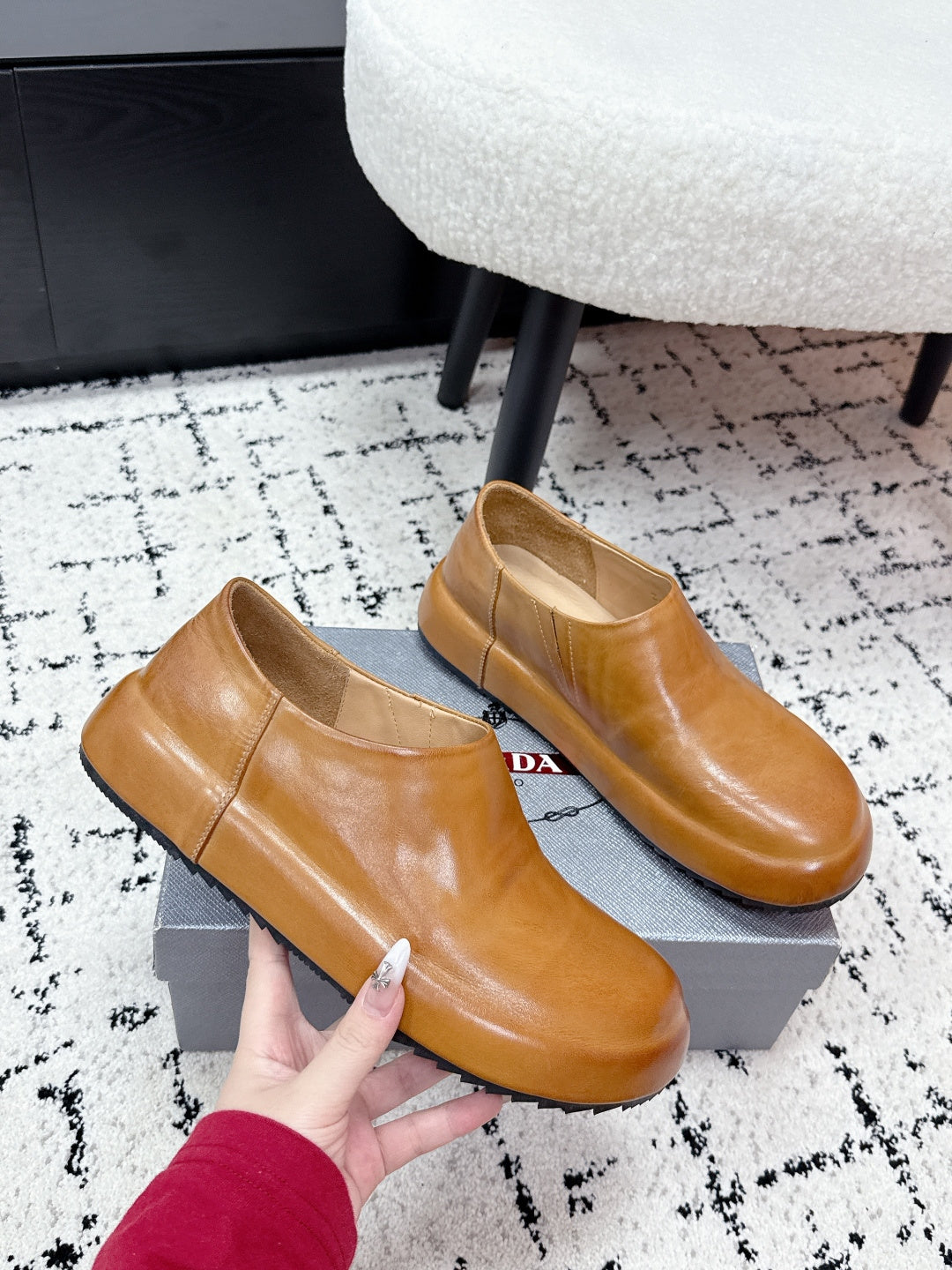 Brown leather slip-on loafers with smooth upper; held for close-up fit.