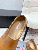 Prada brown leather slip-on loafers, close-up of insole logo and heel.