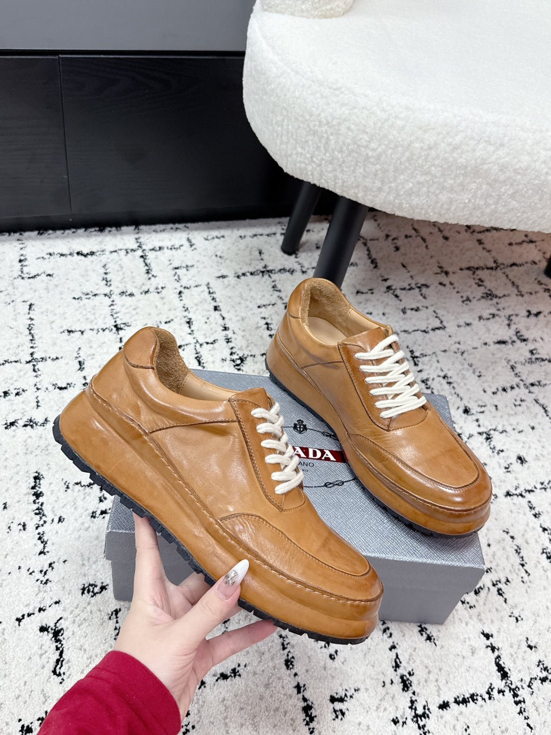 Tan unisex Prada leather low-top sneakers, angled view with white laces