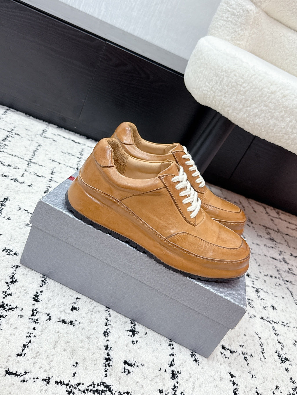 Tan unisex Prada leather sneakers, side profile with white laces and sole