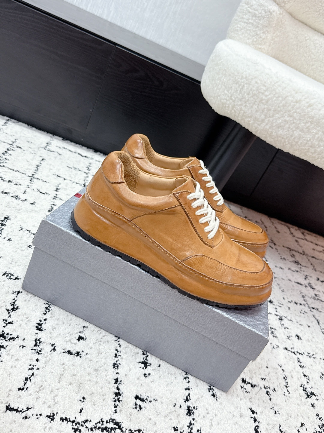 Tan unisex Prada leather sneakers, side profile with white laces and sole