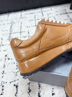 Tan Prada leather low-top sneaker side view with white lace-up