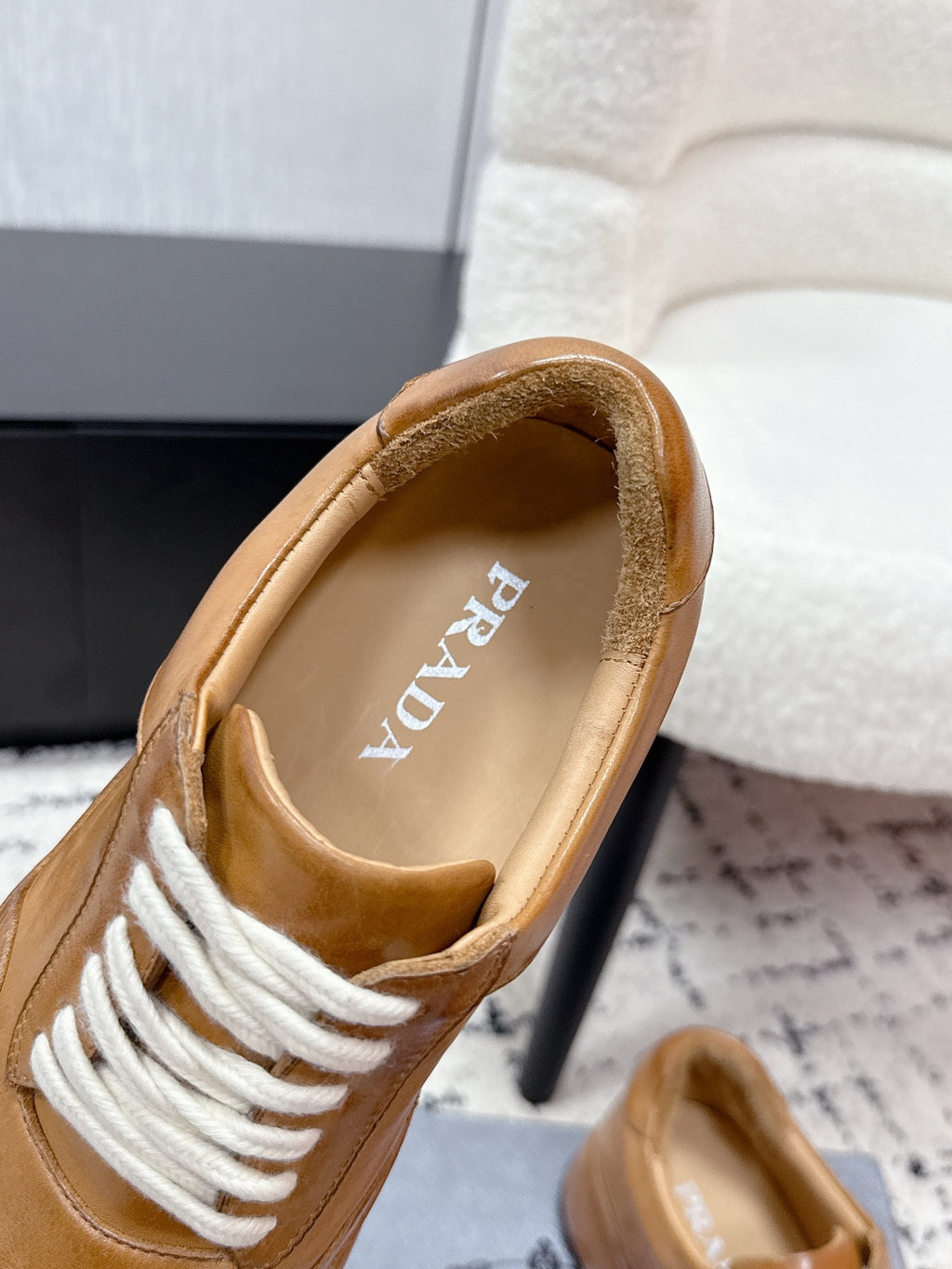 Tan Prada sneaker interior view with white laces and beige lining