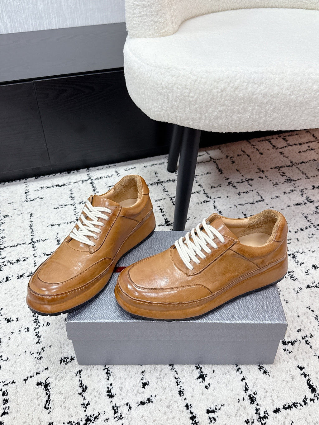 Tan unisex Prada leather low-top sneakers with white lace-up front view