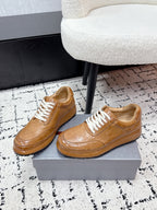 Tan unisex Prada leather low-top sneakers with white lace-up front view
