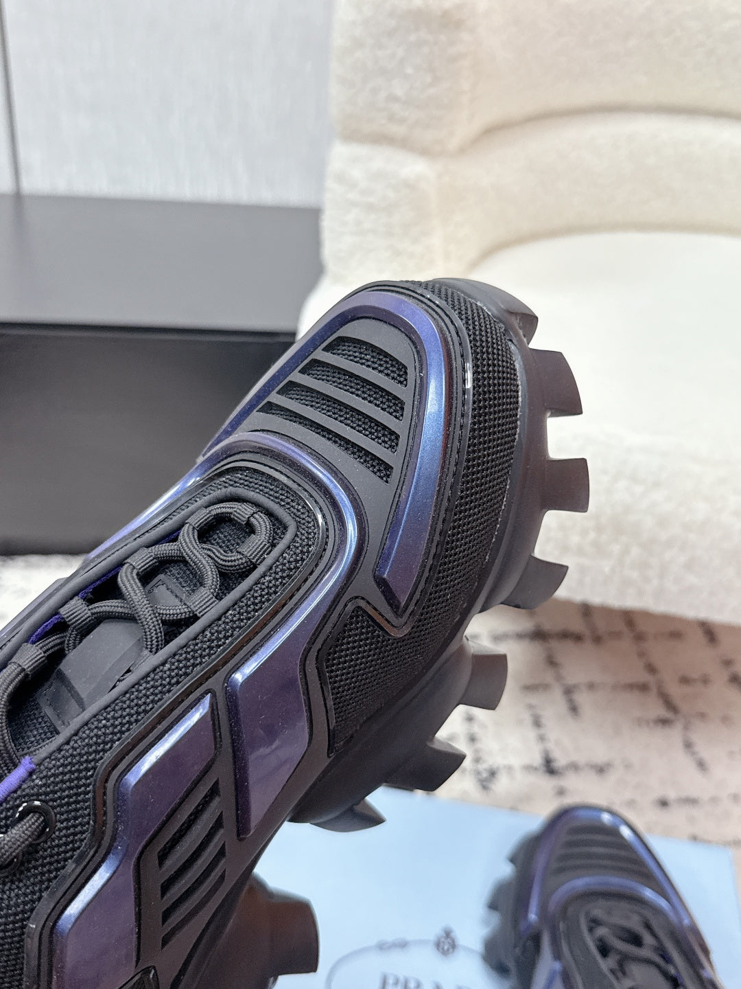 Prada unisex shoes heel close-up, dark gray tread with blue stripe accents