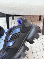 Prada unisex shoes close-up, dark gray upper with blue emblem and purple lining