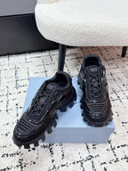 Prada unisex sneakers in black, angled front view with sculpted straps and lug sole